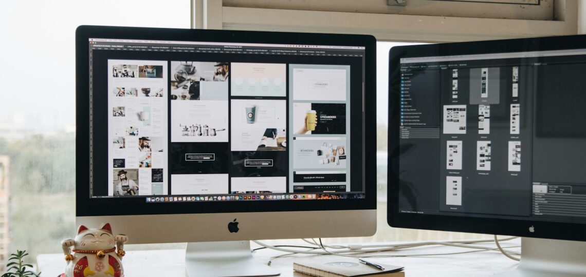 Two monitors setup next to each other on a computer desk.