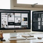 Two monitors setup next to each other on a computer desk.